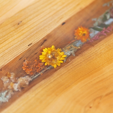 Verschiedene Blumen die in Epoxidharz in einen Tisch eingearbeitet wurden